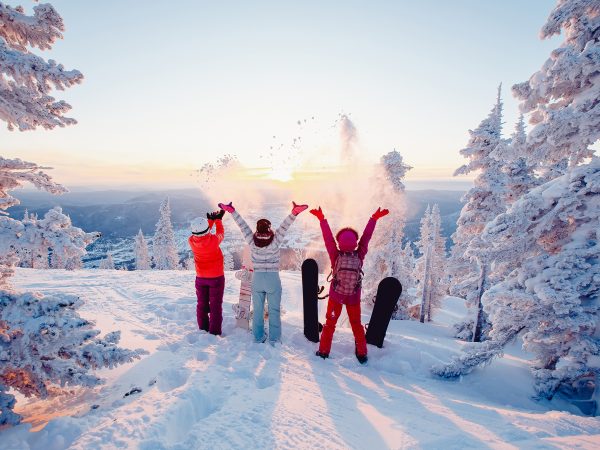 Happy team of snowboarders having fun tossing snow and fun.